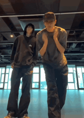 a man in a stussy sweatshirt is dancing with another man