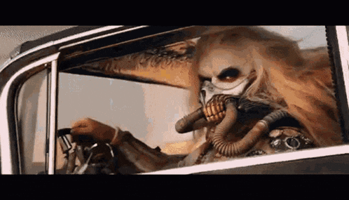 a person wearing a gas mask is sitting in a car .