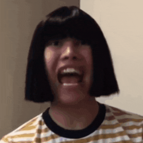 a man wearing a wig and a striped shirt is making a face