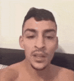 a shirtless man with a beard and mustache is making a funny face .