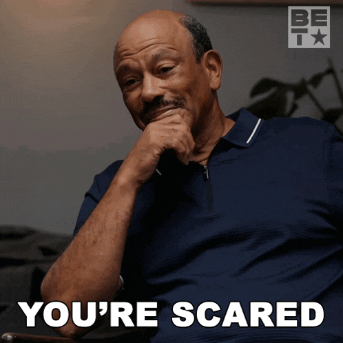 a man sitting in a chair with his hand on his chin and the words you 're scared below him