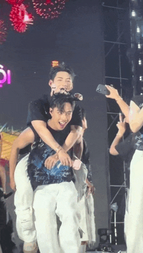 a man is carrying another man on his shoulders on stage