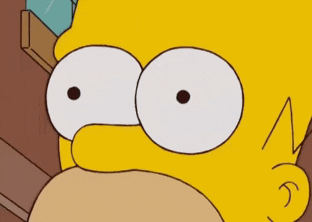 homer simpson from the simpsons is holding two dollar signs in his eyes .