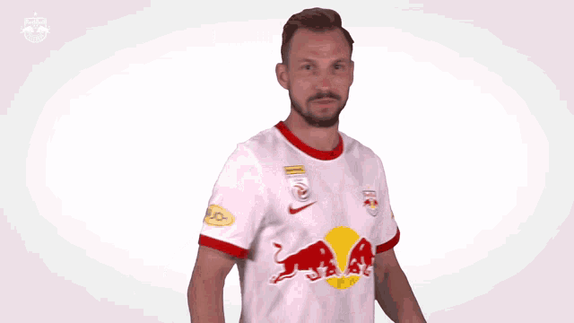 a man wearing a red bull jersey is making a funny face