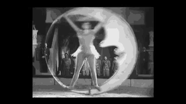 a black and white photo of a woman performing a trick in a bubble .