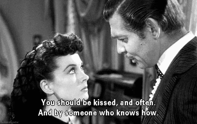 a black and white photo of a man and a woman with the caption " you should be kissed "