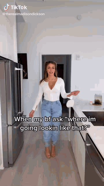 a woman in a white top and blue jeans is standing in a kitchen with the caption " when my bf ask "