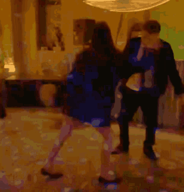 a blurry picture of a couple dancing in a dark room