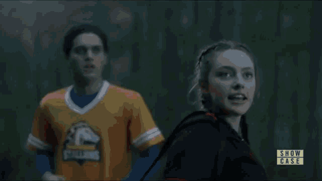 a man and a woman are standing next to each other and the woman is holding a fireball .