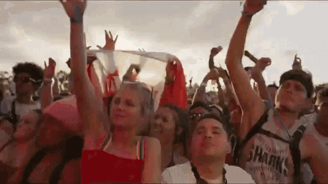a crowd of people at a concert with one wearing a sharks shirt