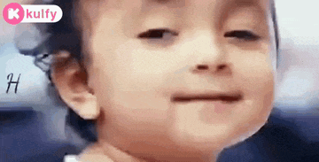 a baby is making a funny face with his eyes closed and his mouth open .