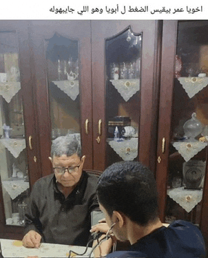 a man is taking a man 's blood pressure in a room