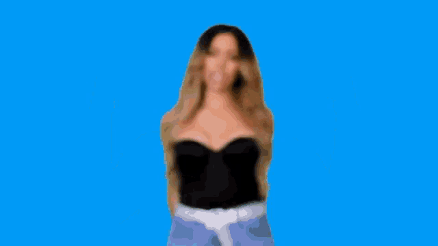a woman in a black dress is making a funny face and pointing at herself .