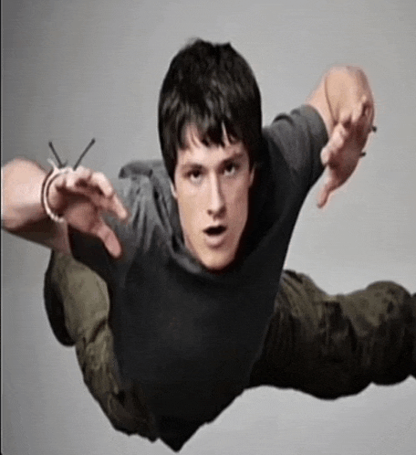 a man in a grey shirt is flying through the air