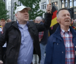 a man in a white hat holds up a flag