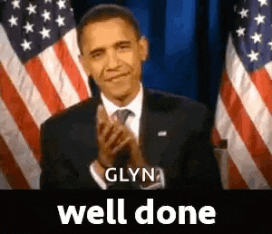 barack obama is applauding in front of an american flag while standing in front of two american flags .