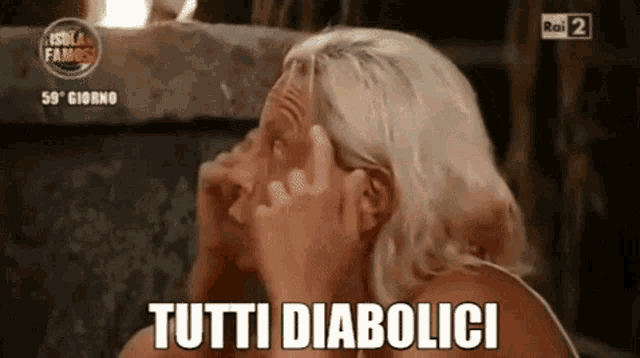 a woman is covering her face with her hands and the words tutti diabolici are on the screen .