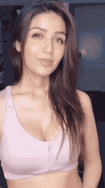 a woman is wearing a purple sports bra with a zipper on the front