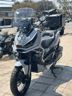a motorcycle with a large windshield is parked on a tiled sidewalk