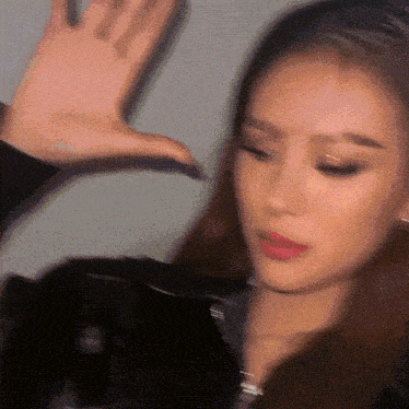 a blurry picture of a woman 's face with her hand in the air