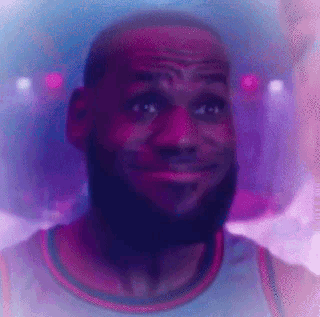 a close up of a man 's face with a beard in a purple and blue light .