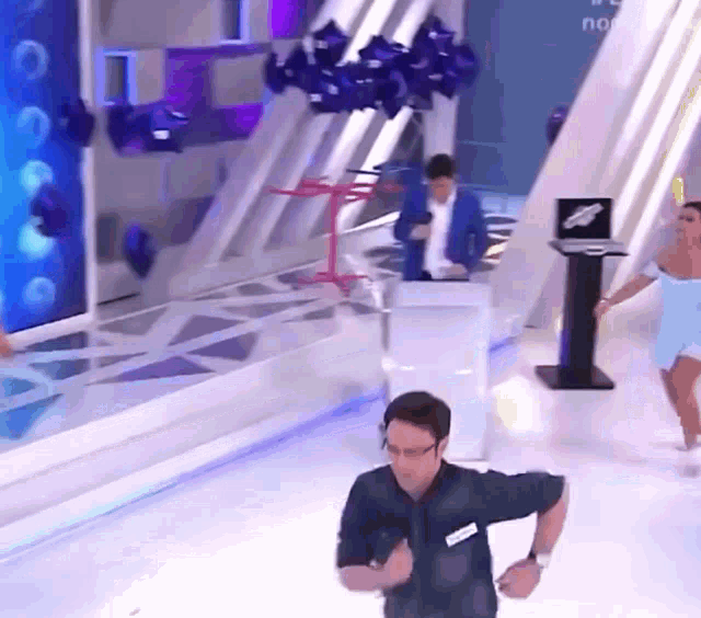 a man with a name tag on his shirt is running in front of a woman