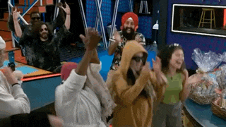 a group of people are dancing together in a room with their hands in the air .