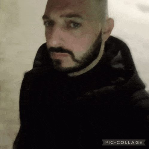 a man with a beard is wearing a black coat