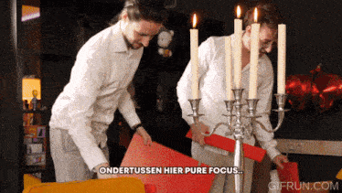 a gif from gifrun.com shows two men standing next to candles