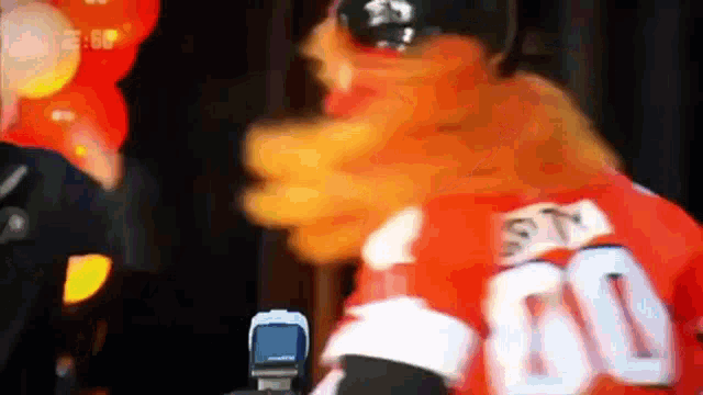 a mascot is wearing a red jersey with the number 60 on it