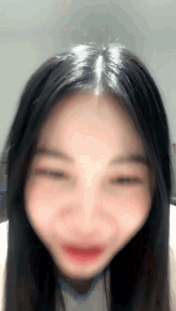 a woman with long black hair is making a funny face with her eyes closed