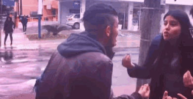 a man and a woman are standing next to each other on a sidewalk