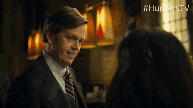 a man in a suit and tie talks to a woman with #hunterstv on the bottom right