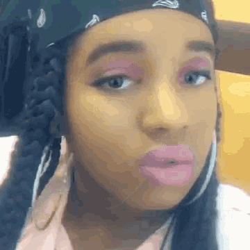a close up of a woman wearing a bandana and earrings