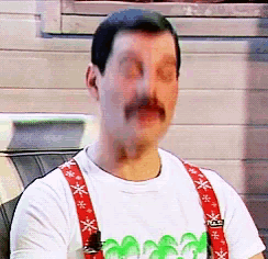 a man with a mustache wearing suspenders and a t-shirt with palm trees on the front