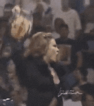a woman is holding a stuffed animal in her hands in a crowd .