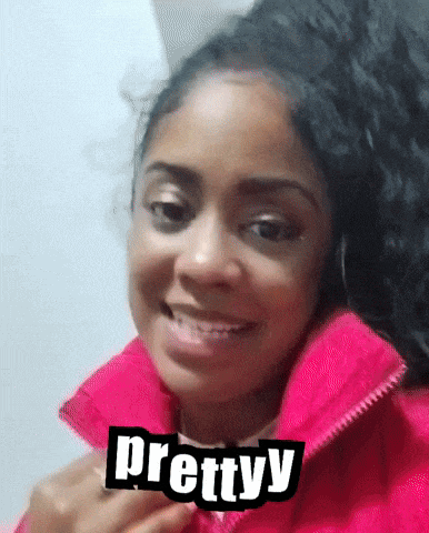 a woman wearing a pink jacket has the word prettyy on her collar