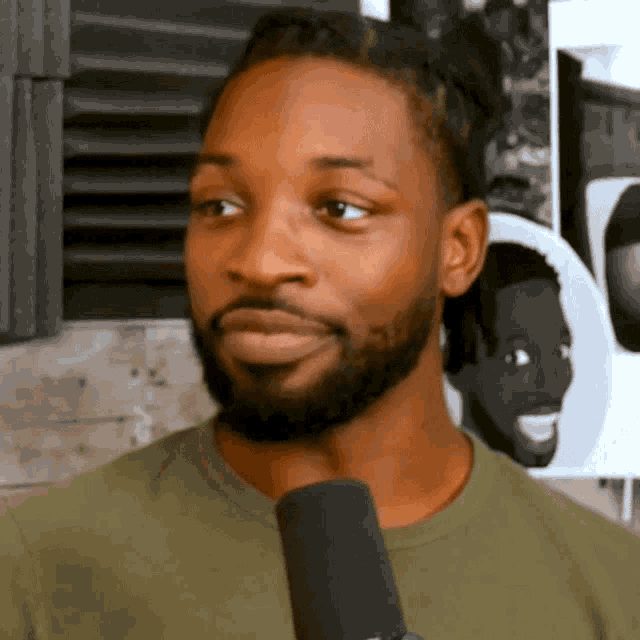 a man with a beard holds a microphone in front of him