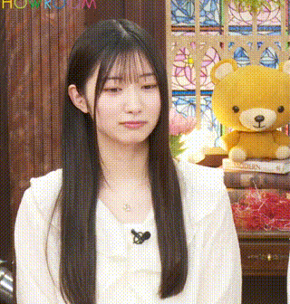 a woman is sitting in front of a teddy bear and a book .