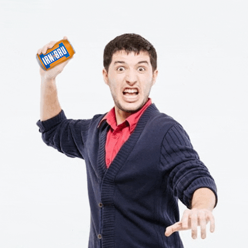a man in a blue cardigan is holding up a can of ign-bru