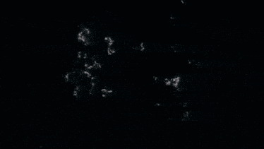 a man wearing sunglasses and a white tank top is standing in a dark room looking up .