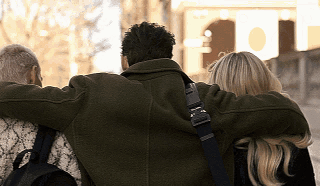 a man in a green coat is hugging a woman