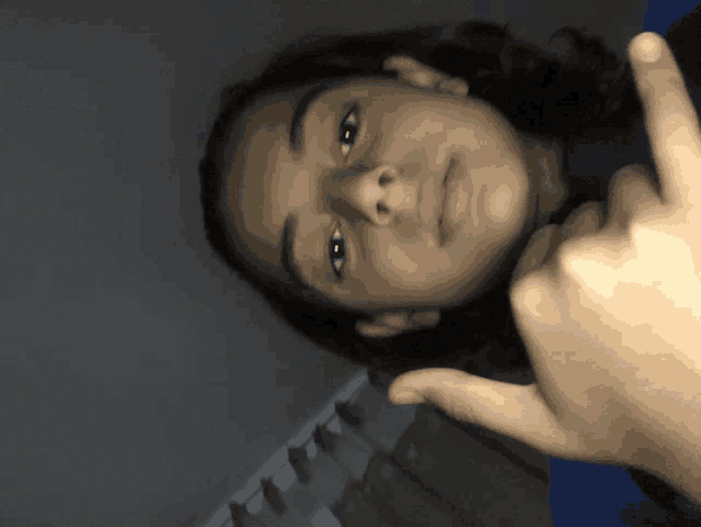 a young girl giving a thumbs up sign