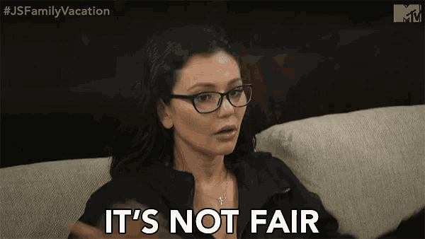 a woman with glasses is sitting on a couch and says it 's not fair .