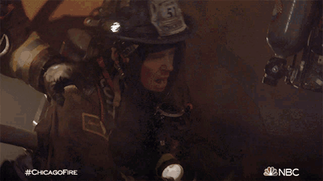 a fireman with the number 51 on his helmet holds a flashlight
