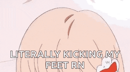 a person is laying on their stomach on a bed in a room with a desk and a table .