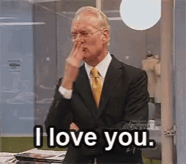 a man in a suit and tie is covering his nose and says i love you