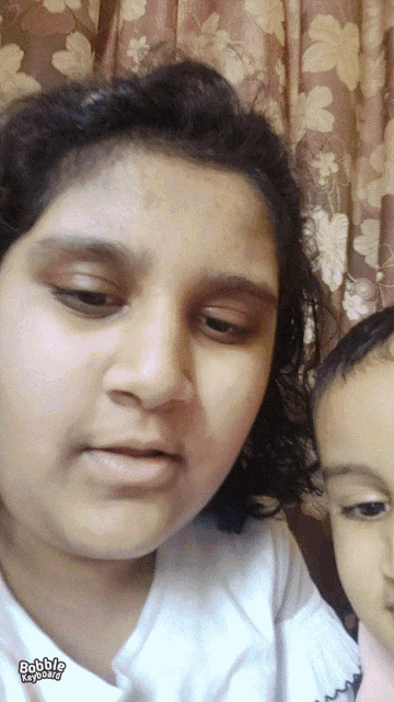 a woman and a child are posing for a picture with the words bobble emoji on the bottom left