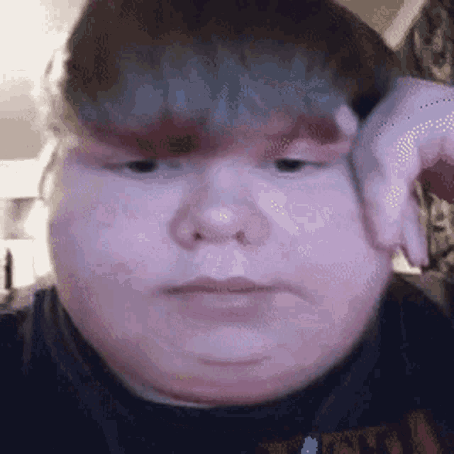 a close up of a person 's face with their hand on their face