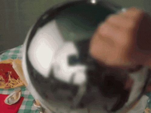 a close up of a person 's hand holding a silver ball